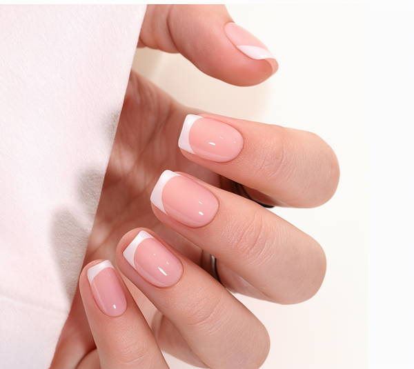 Close-up of a hand with pink nail polish on a white background